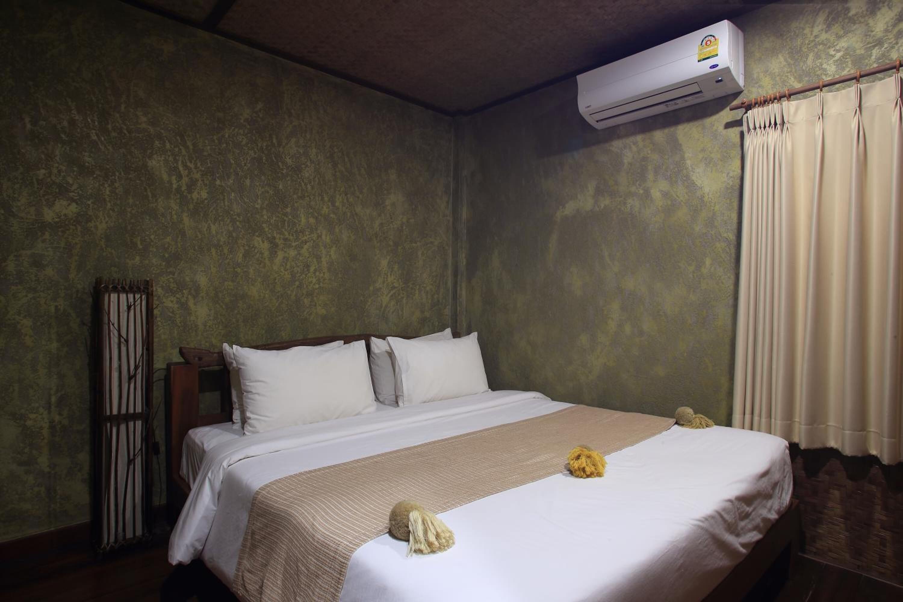 Une chambre d’hôtel avec un lit, un rideau et un appareil de climatisation.