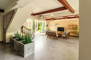 A spacious living area with a staircase, seating, and a television. - Cerulean View (Hanimaadhoo)