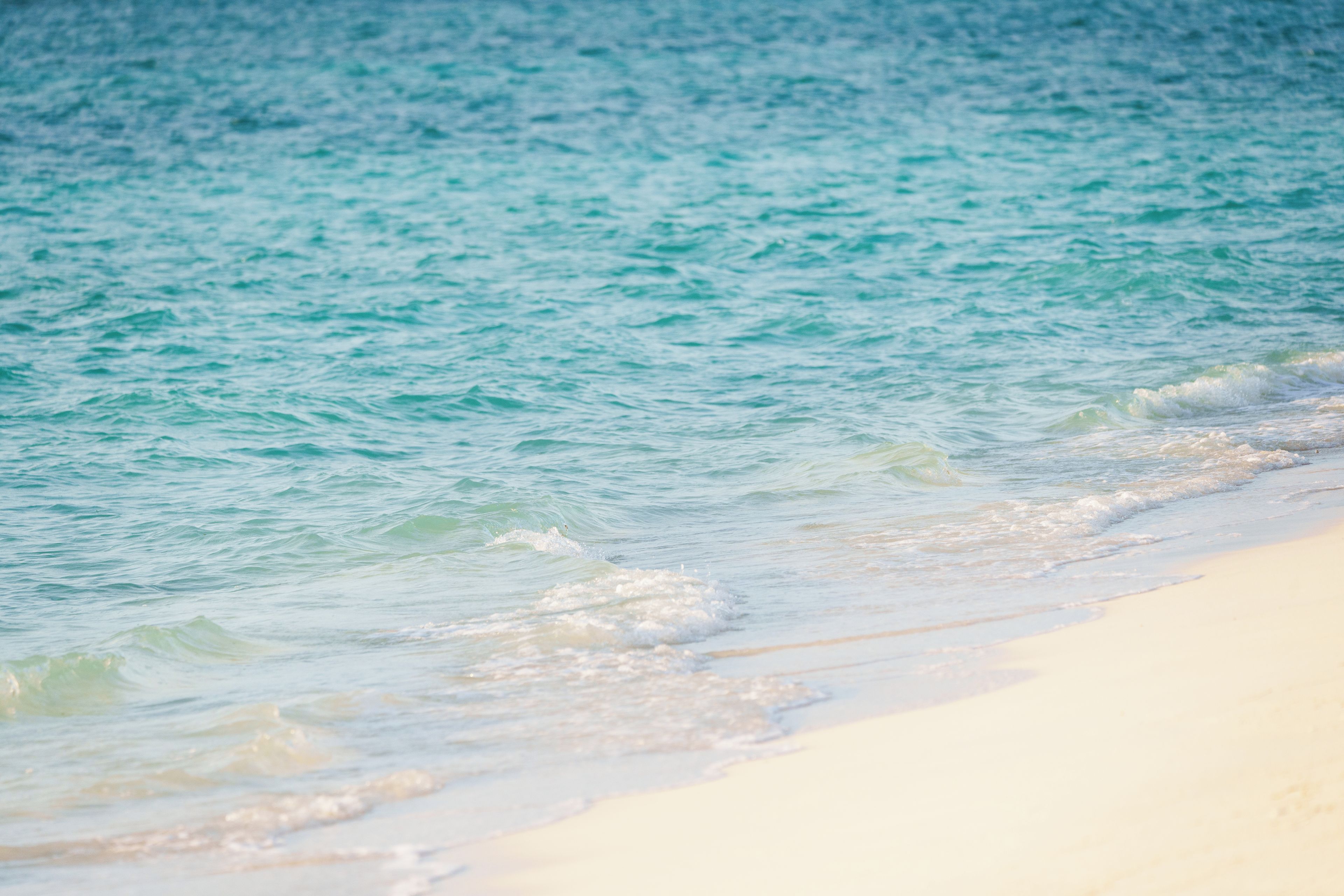 A beach with clear turquoise water and white sand.
