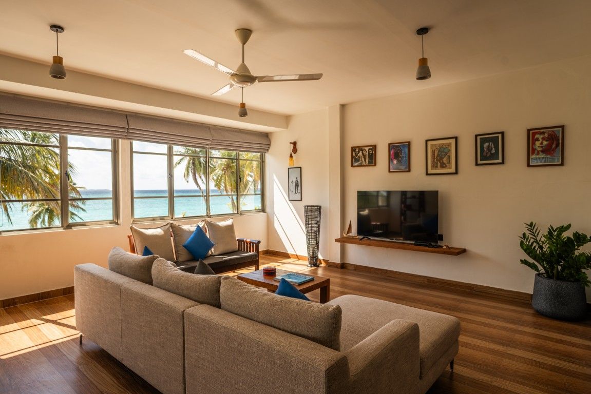 Una sala de estar con sofá, televisión y una obra de arte en la pared.