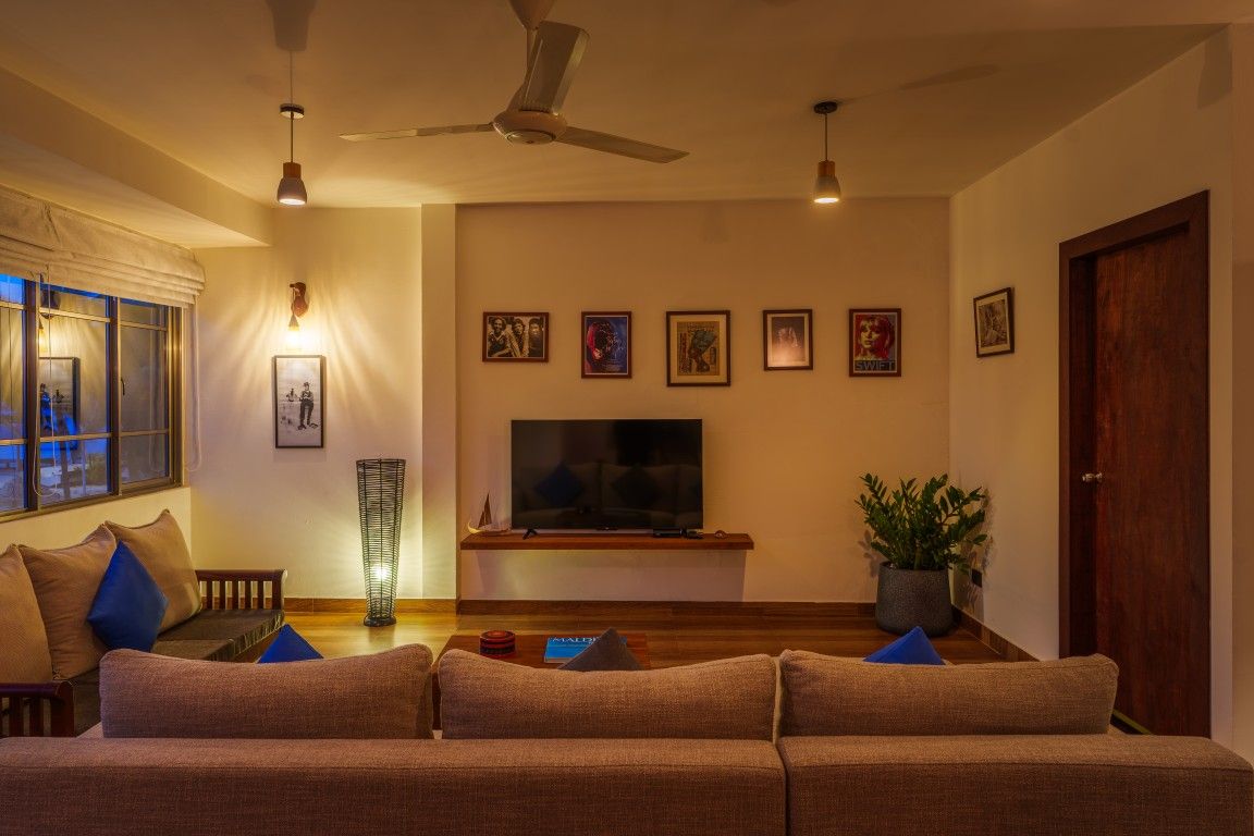 A living room with a sofa, a television, and wall-mounted artwork.