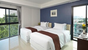 A hotel room with two beds, a large window, and a view of the city. - Casa Residence Hotel (Bangkok)