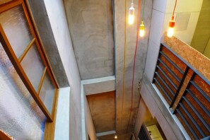 A narrow stairwell with a wooden handrail and a glass door. - Puli Center Center Hostel (Puli)
