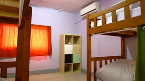 A bunk bed room with a wooden bunk bed, a green curtain, a wooden wardrobe with multiple compartments, and a window with orange curtains. - Puli Center Center Hostel (Puli)