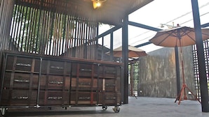 A spacious area with a large wooden cabinet, metal-framed ceiling, and a concrete floor.
