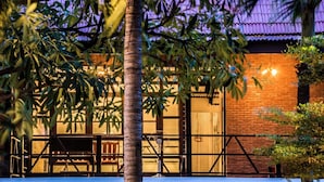 A building with a brick facade, a wooden deck, and a pool area.