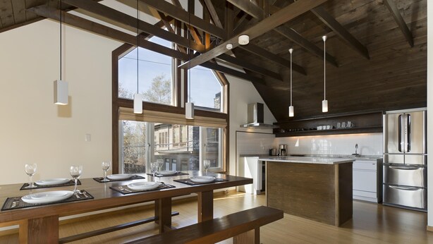 A modern kitchen with wooden beams, large windows, and stainless steel appliances. - Ginsetsu (Kutchan)