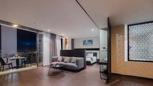 Une chambre d’hôtel moderne dotée d’un balcon, d’un canapé, d’une table à manger et d’un lit.