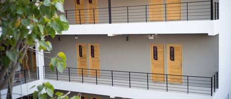 A multi-story building with numbered wooden doors and balconies.
