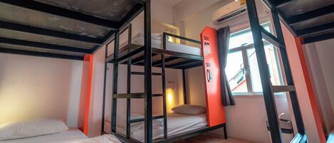 A bunk bed room with a window, a heater, and a door.
