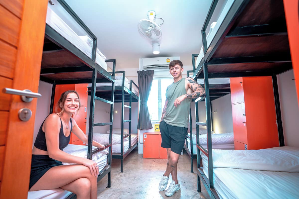 Un dormitorio con literas, un ventilador y una ventana con cortinas.