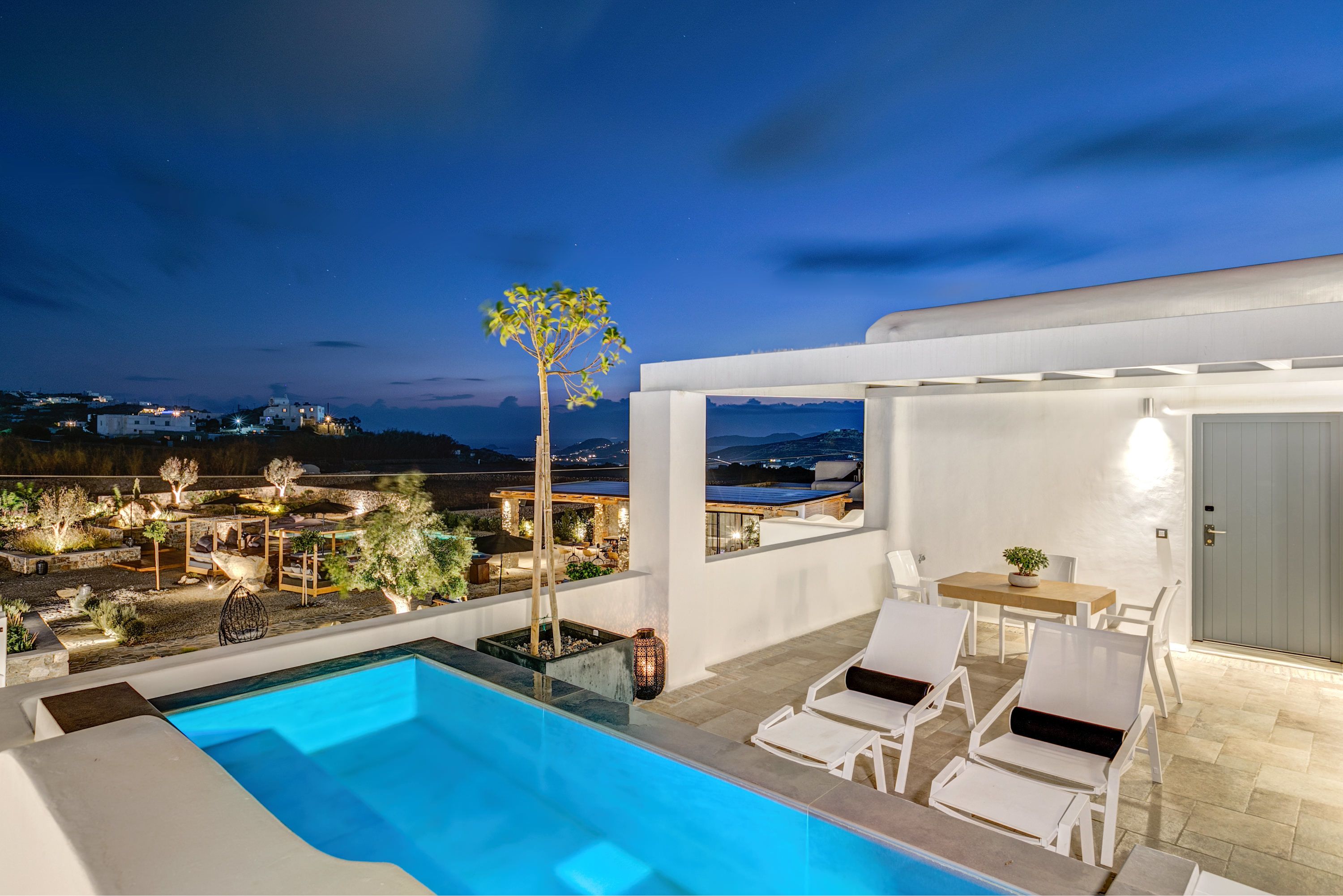 A modern outdoor pool area with lounge chairs and a view of the landscape.