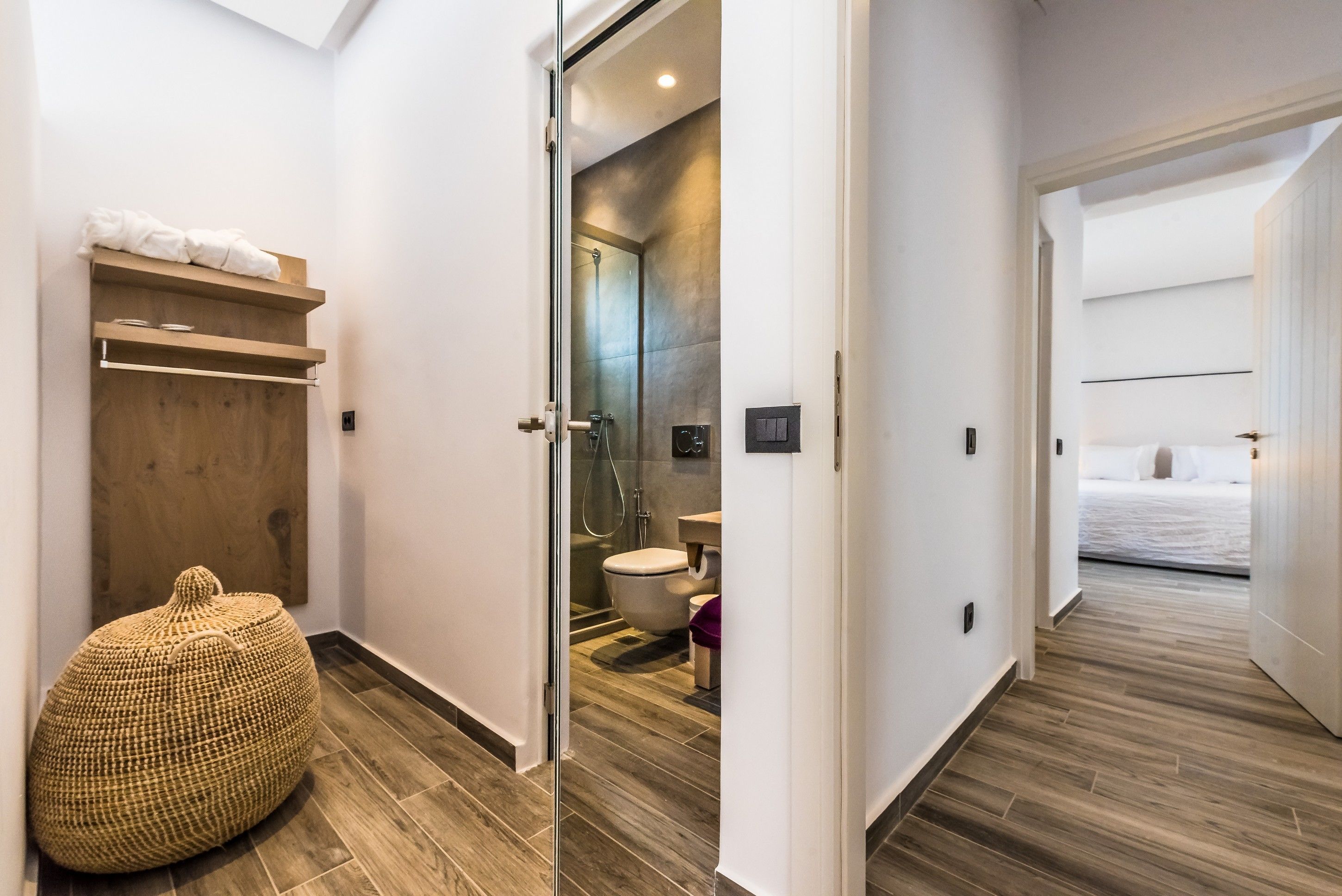 Een moderne badkamer met een douche, toilet en een douchecabine met glazen wanden.