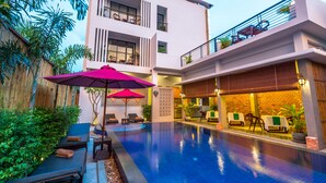 A modern hotel with a swimming pool, outdoor seating, and a restaurant area. - Silver Palms Residence (Siem Reap)