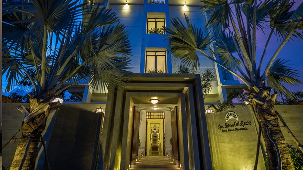 A modern building with a staircase leading to a door, palm trees, and a sign reading "Silver Palms Residence". - Silver Palms Residence (Siem Reap)