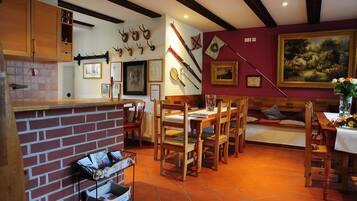 Comedor con pared de ladrillo, mobiliario de madera y un cuadro en la pared.
