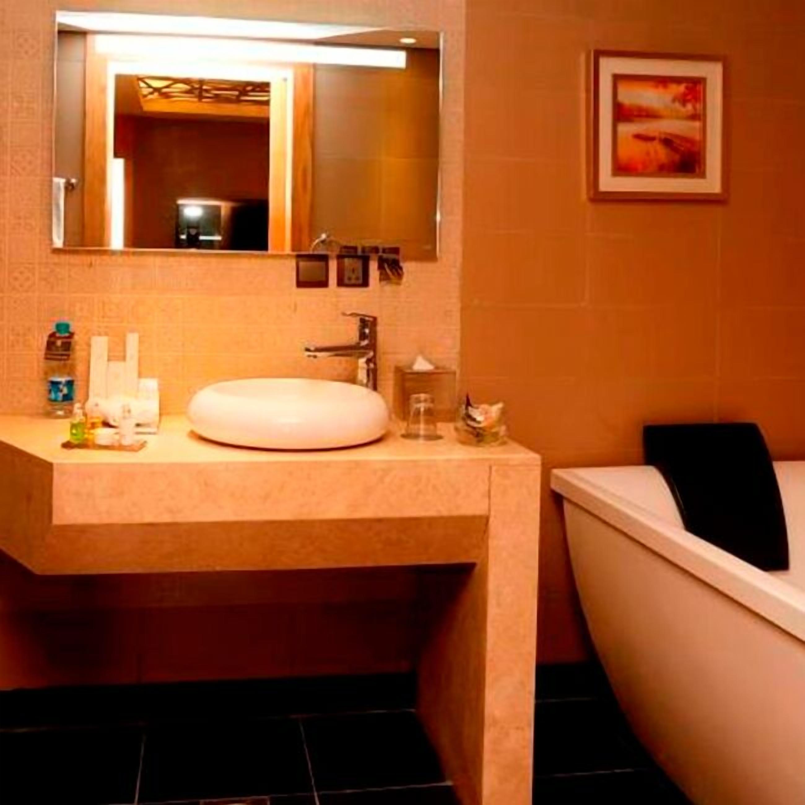 A bathroom with a white sink, mirror, and bathtub.