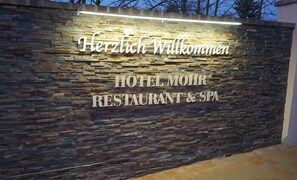 A stone wall with the text "Herzlich Willkommen" and "HOTEL MOHR RESTAURANT & SPA" indicating a welcoming sign for a hotel, restaurant, and spa. - Hotel Mohr & SPA (Werder (Havel))