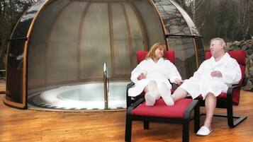 A transparent dome structure with two red cushioned chairs inside.