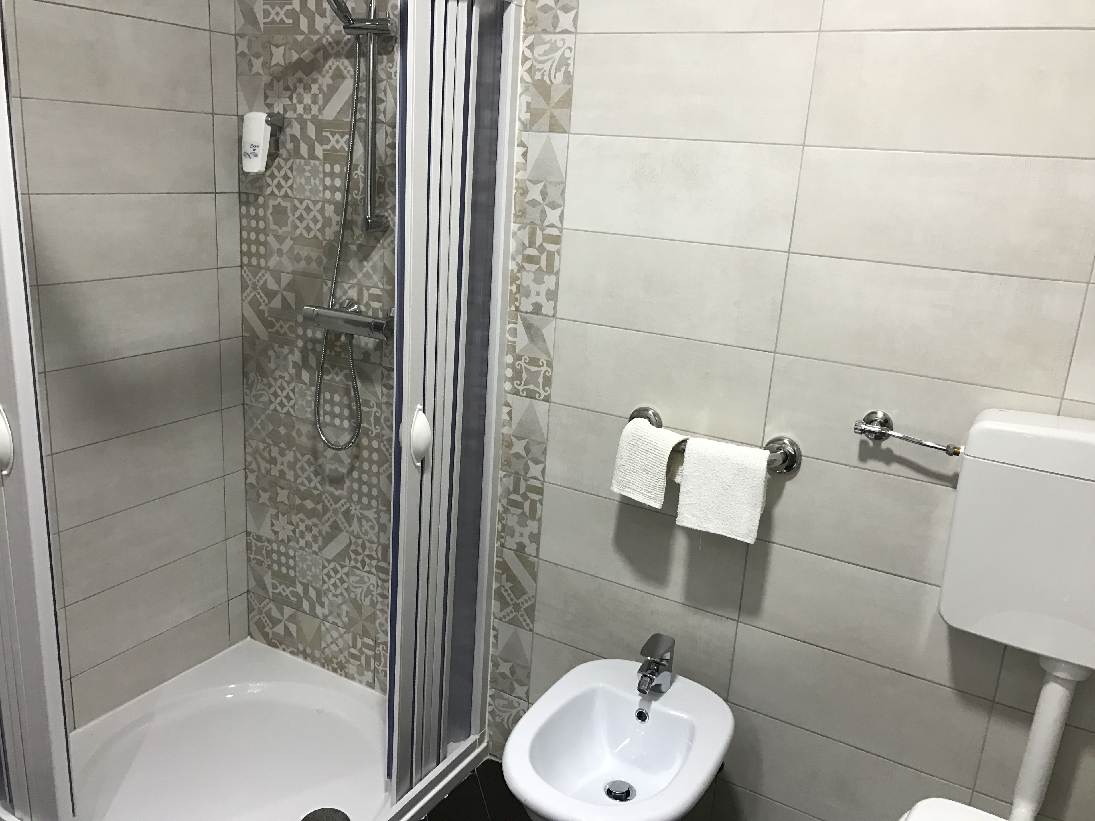 Un bagno con doccia, lavandino e WC.