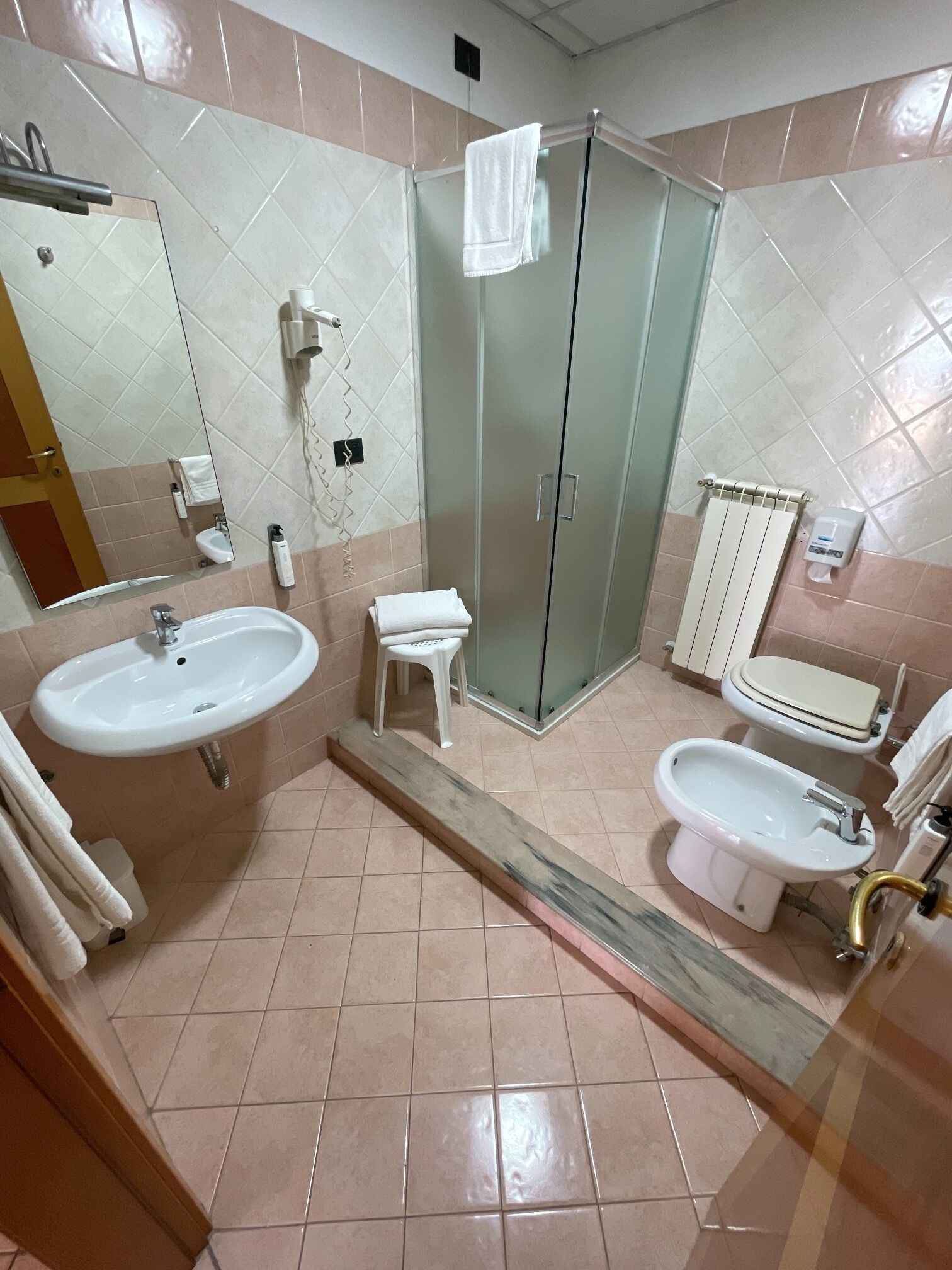 Ein Badezimmer mit Waschbecken, Bidet, Toilette und einer Duschkabine aus Glas.