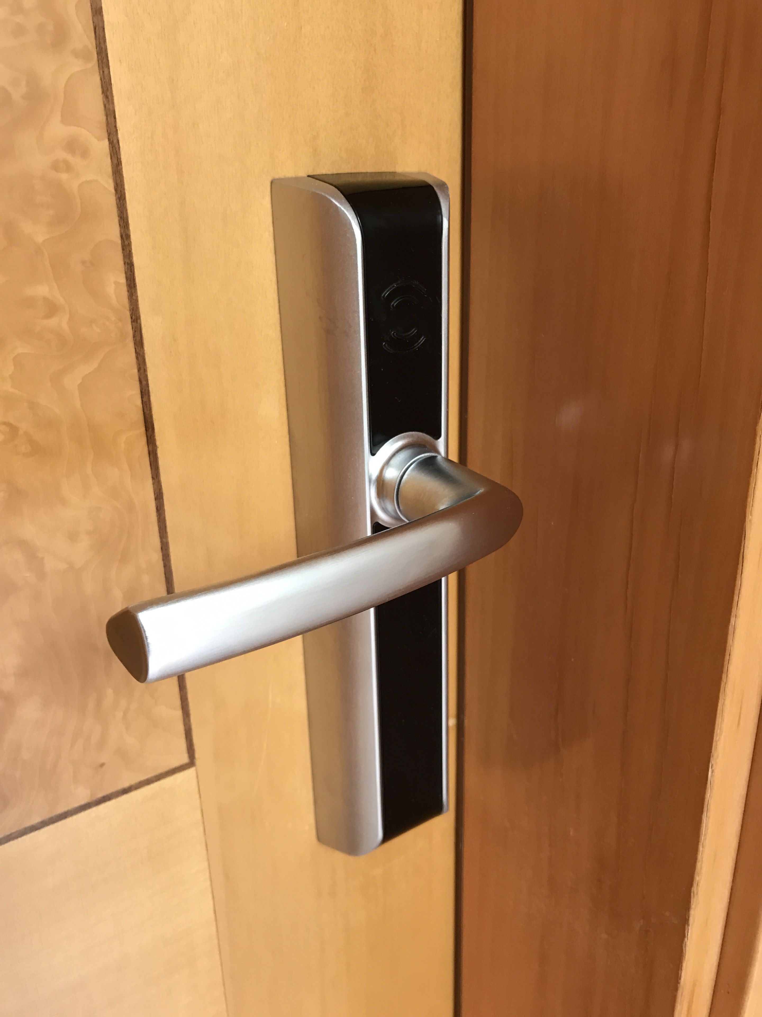 A modern door with a metallic handle and a keyhole.