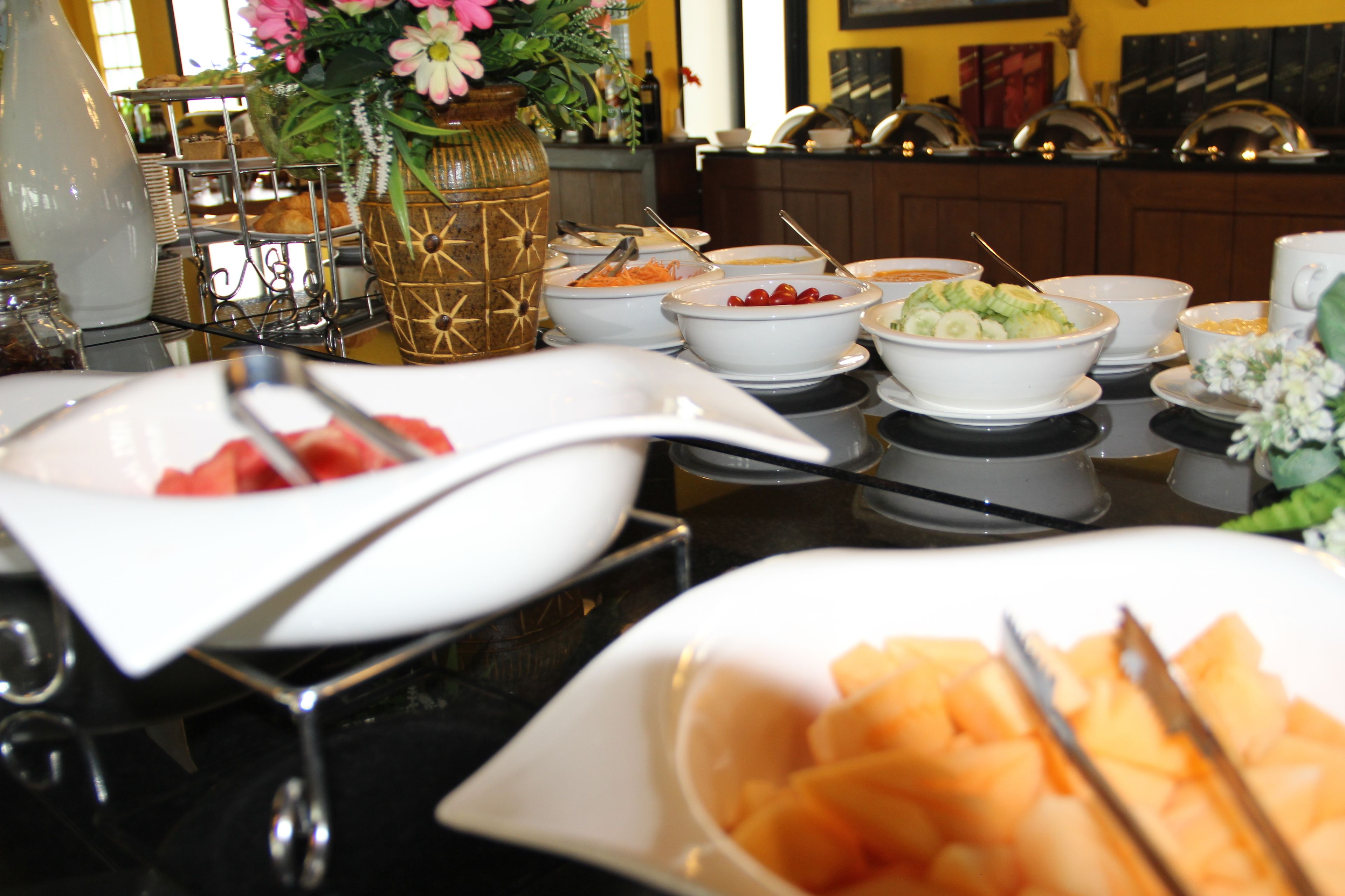 A buffet table with various food items and serving utensils.