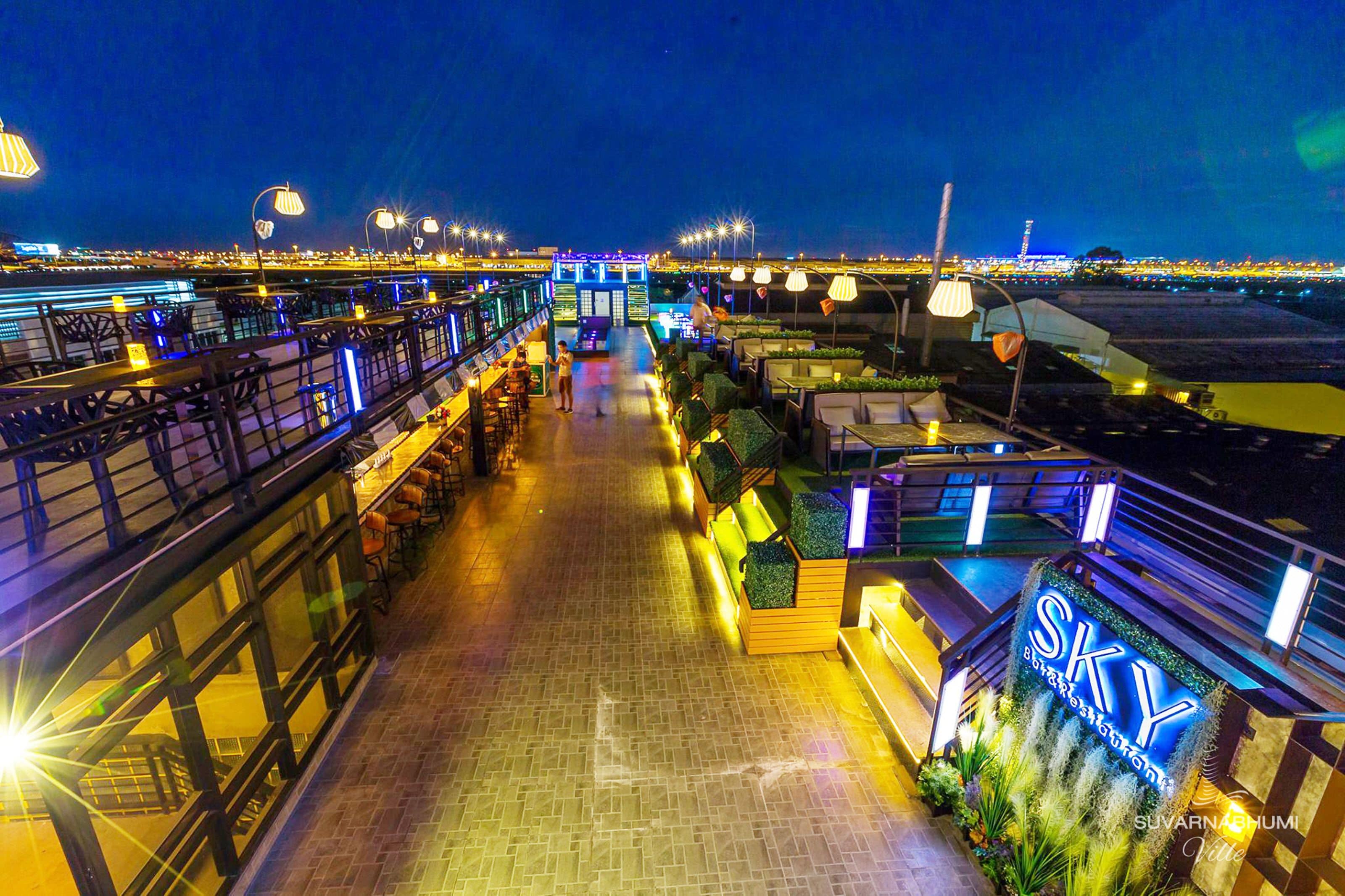 A rooftop bar with outdoor seating, a pool, and a sign reading "SKY".