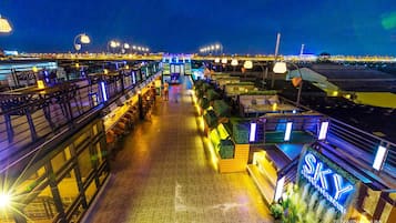 A rooftop bar with outdoor seating, a pool, and a sign reading "SKY".