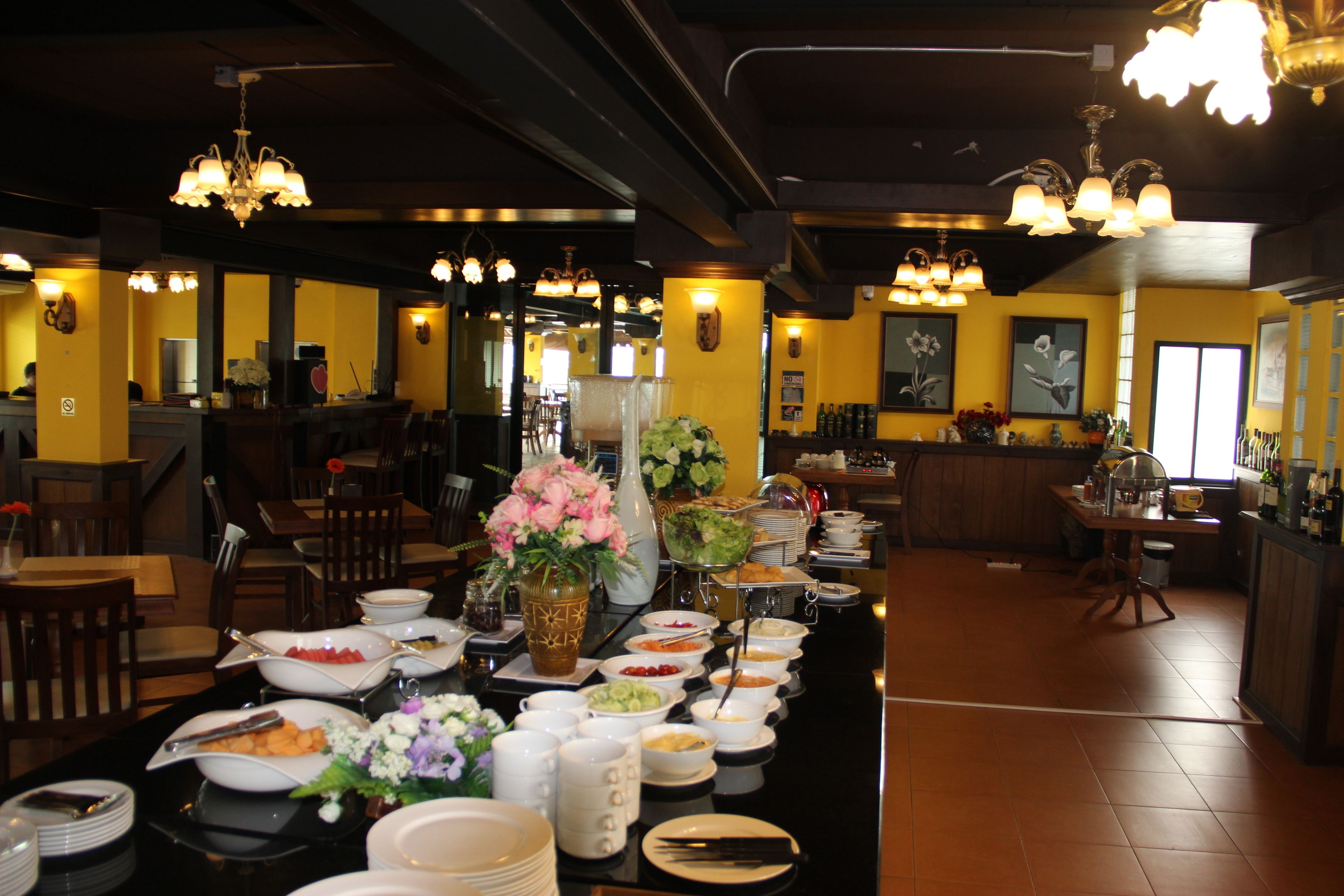Disposição de buffet com diversos alimentos e um arranjo floral.