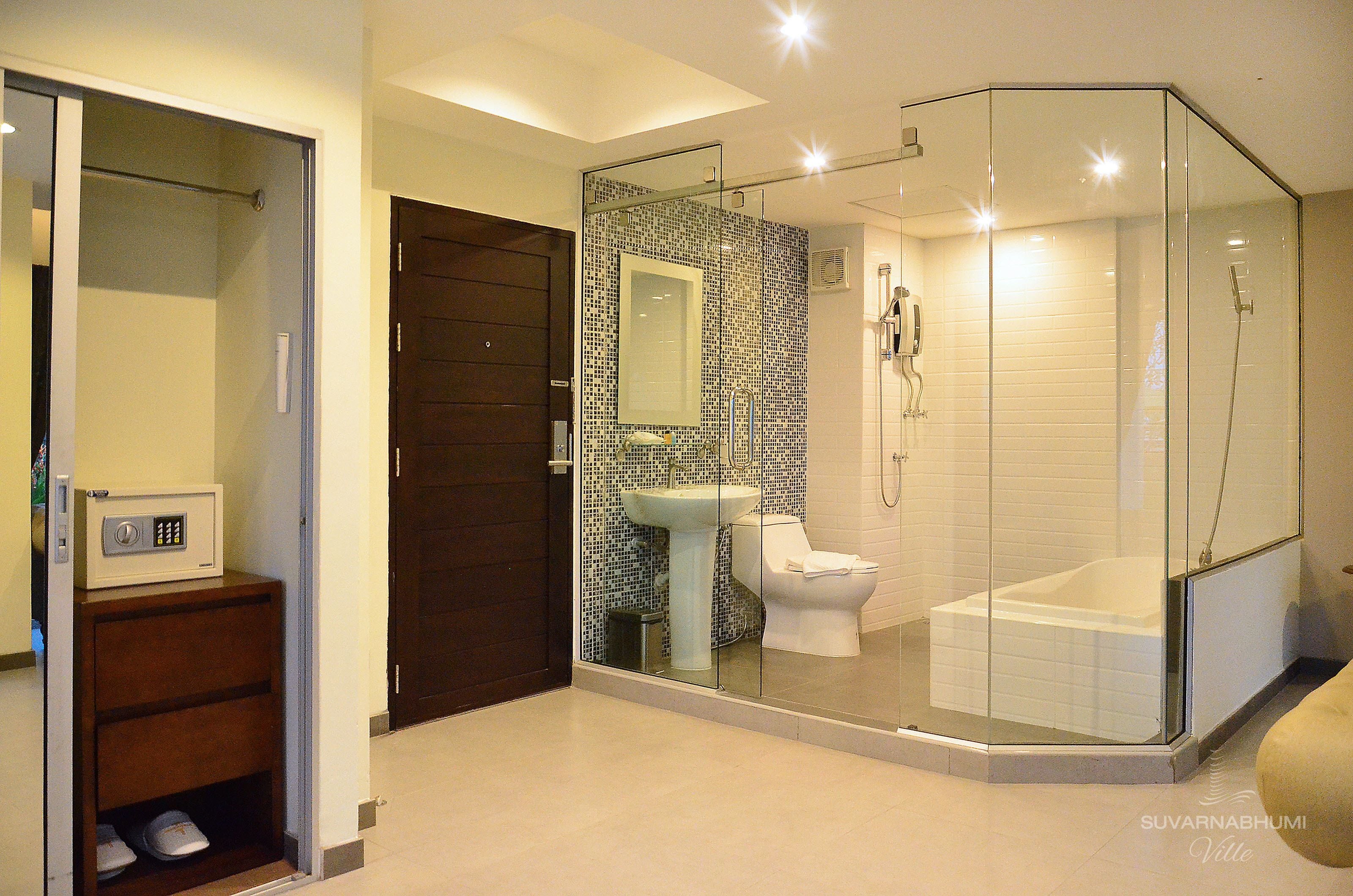 A modern bathroom with a glass-enclosed shower, a white sink, and a toilet.