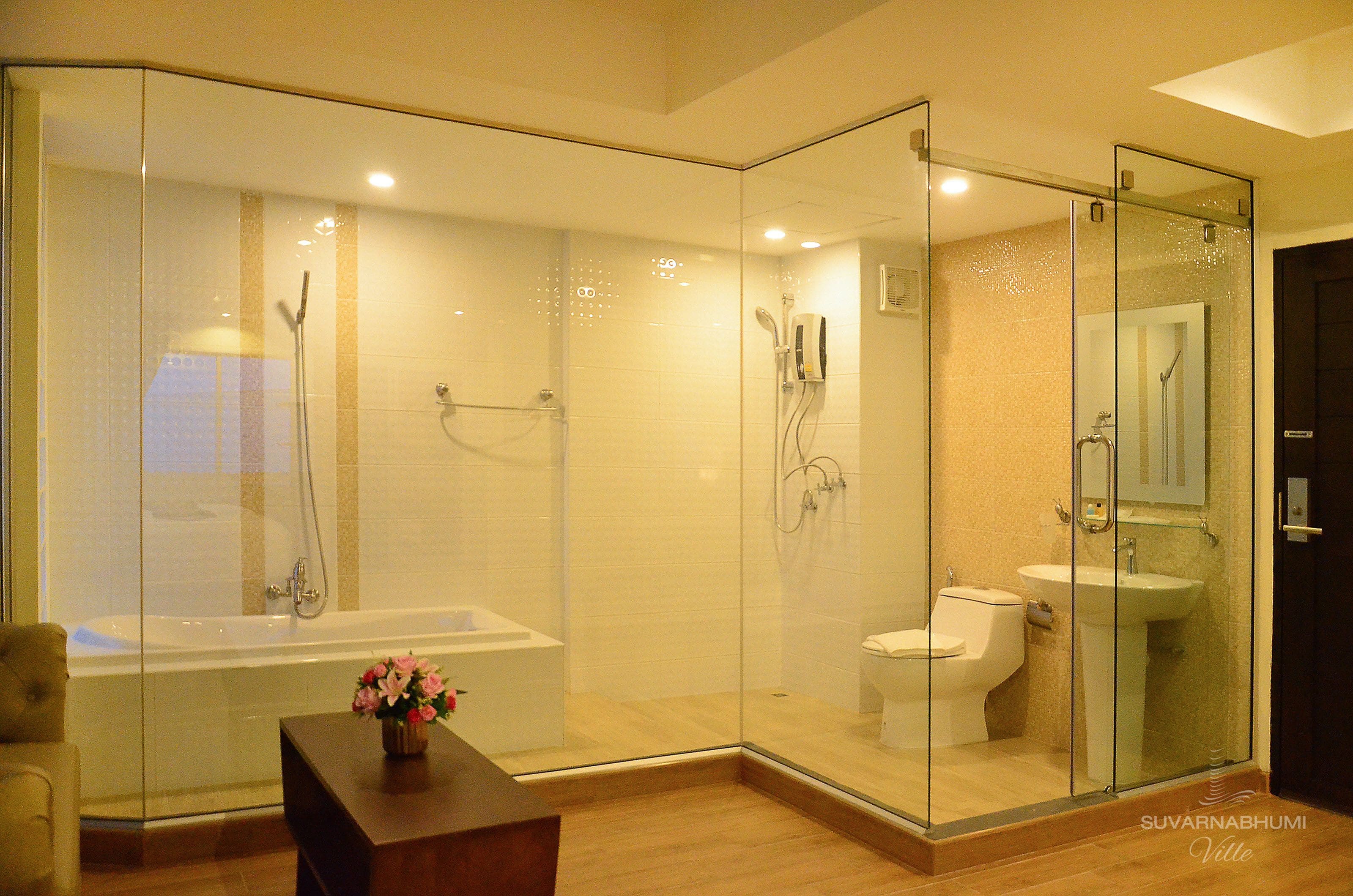 A modern bathroom with a glass-enclosed shower, a bathtub, and a toilet.
