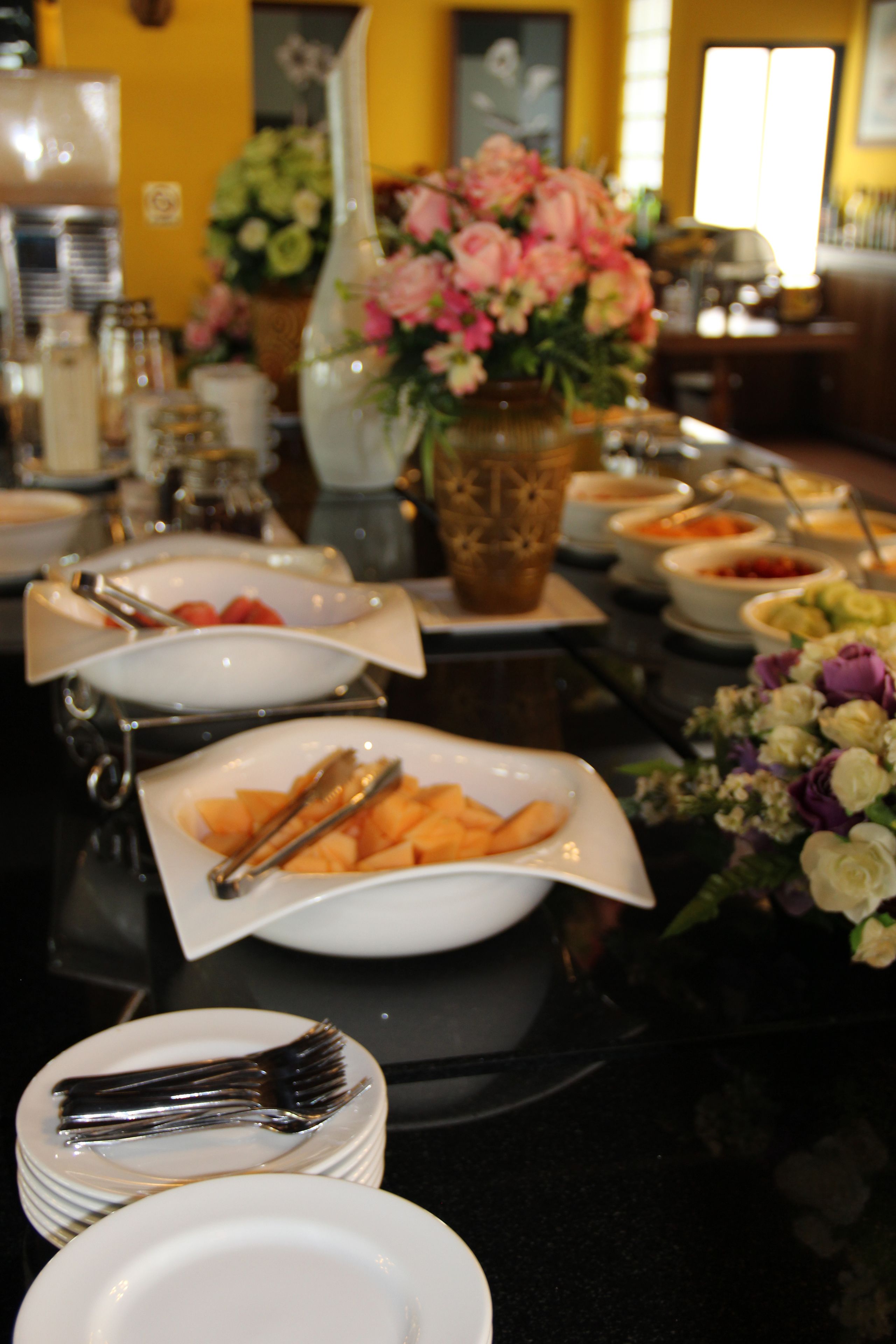 Una mesa de buffet con diferentes platos y utensilios.