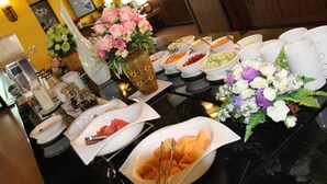 Ein reichhaltiges Buffet mit verschiedenen Speisen und einer Blumenvase.