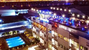 A multi-story hotel with a rooftop bar and pool area. - Suvarnabhumi Ville Airport Hotel (Bang Phli)