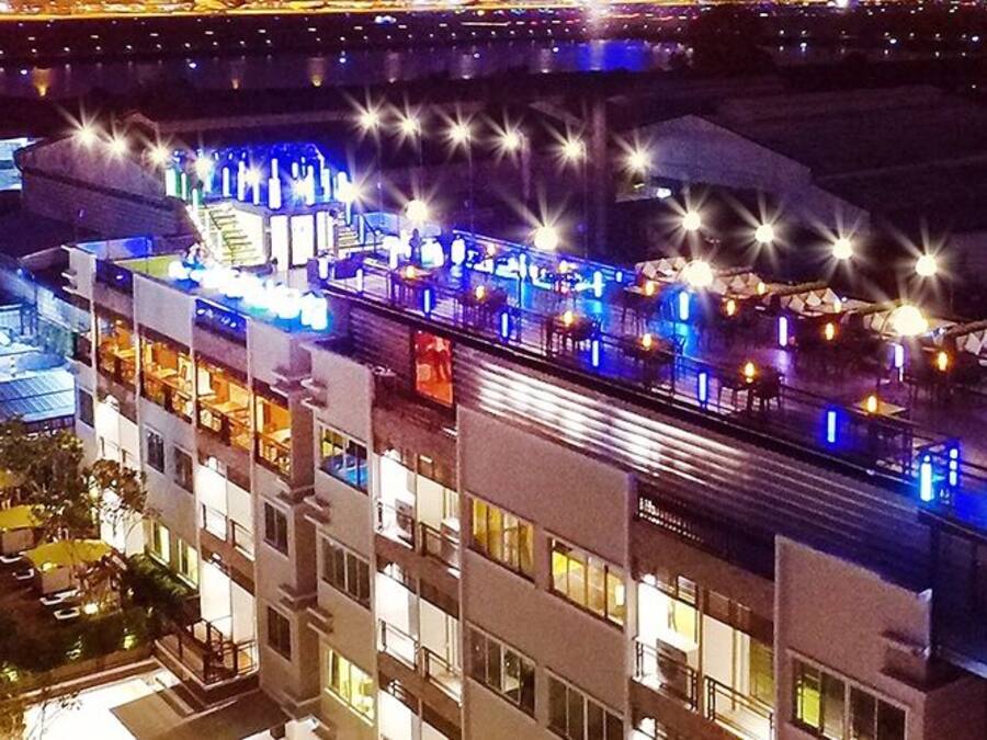 Un hôtel à plusieurs étages doté d’un bar et d’une piscine situés sur le toit.