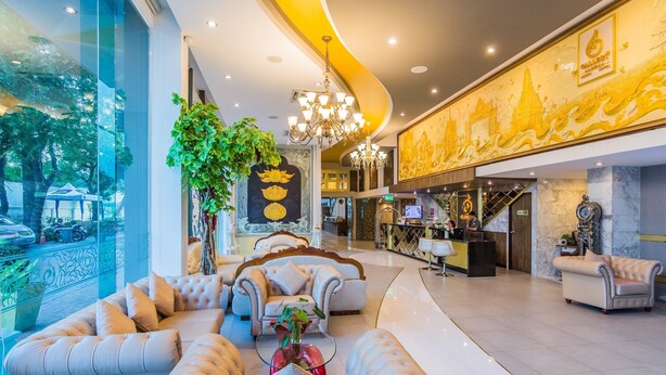 A spacious lobby with a curved ceiling, a reception desk, and a seating area with sofas and armchairs. - Gallery Design Hotel (Sisaket)