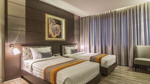 A hotel room with two beds, a large painting on the wall, and a view of the city. - Gallery Design Hotel (Sisaket)