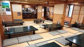 Ett traditionellt japanskt rum med tatamimattor, låga bord och kuddar.