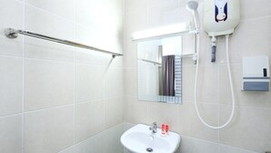 A bathroom with a white sink, a handheld showerhead, a towel rack, and a mirror. - Hotel O Midah Inn Puchong (Seri Kembangan)