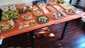 A table with various food items and condiments, including pastries, bread, and a pitcher of juice. - Villa Concordia (Agrigento)