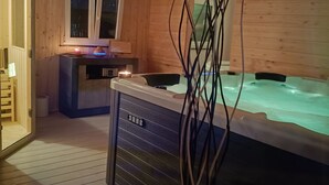 A wooden cabin interior with a hot tub, a window, and a door leading outside. - Villa Concordia (Agrigento)