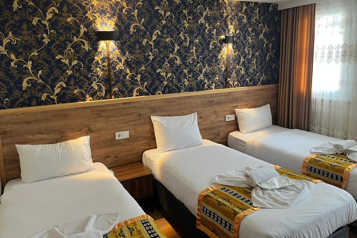 Standard Triple Room | Peralatan tempat tidur premium, peti besi dalam bilik, meja 