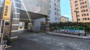 A hotel entrance with a sign reading "Green Hotel" and a directional sign for parking.