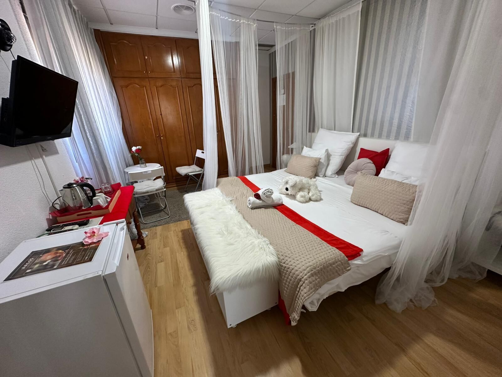 Una habitación de hotel con cama, televisión, escritorio y silla.
