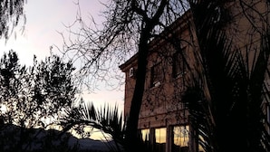 A building with a large window, surrounded by trees and a clear sky. - Hotel Argos Murcia (Cehegin)