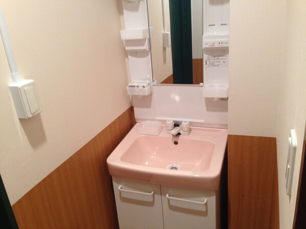 A bathroom with a pink sink, white cabinets, and a mirror. - Fukuoka Guest House Little Asia Kokura - Hostel (Kitakyushu)