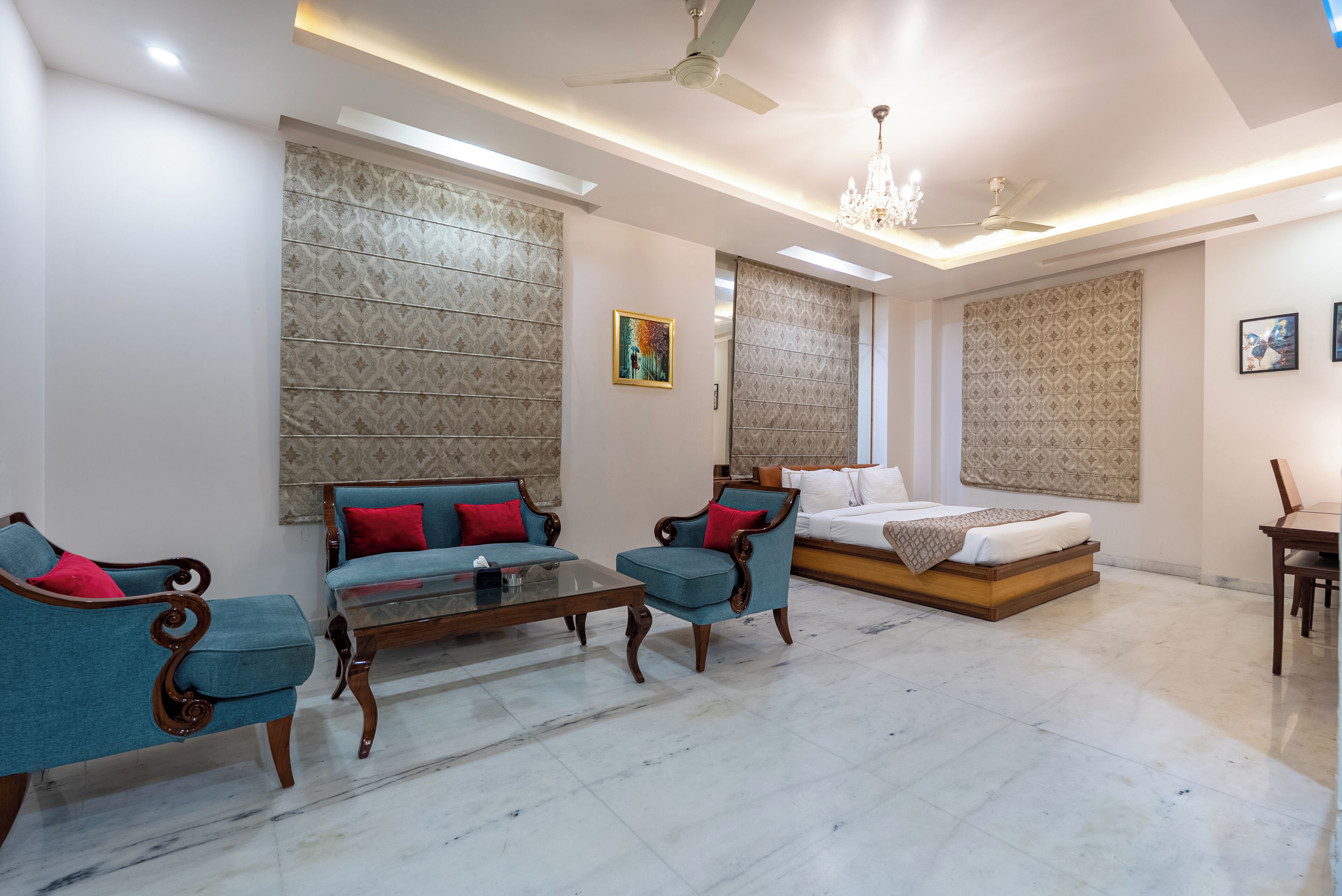A spacious room with a bed, two sofas, a coffee table, and a dining table.