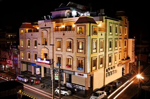 A multi-story building with commercial spaces on the ground floor, including a restaurant and a store. - Leela Grande Hotel (Karnal)