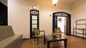 A room with a wooden table, two chairs, a sofa, and a decorative ceiling light. - Green Villa (Unawatuna)